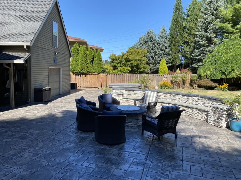 Stamped concrete patio with outdoor seating and stone wall by 4 Belt Concrete, Portland OR